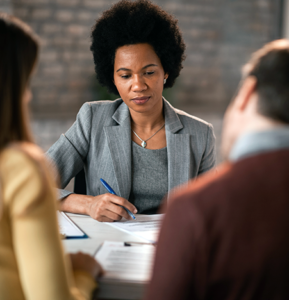 Female financial advisor reviewing paperwork with her clients