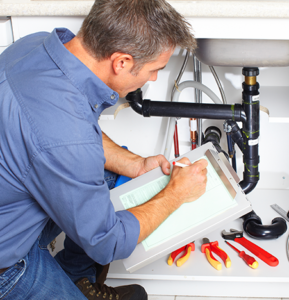Male plumber repairing kitchen sink
