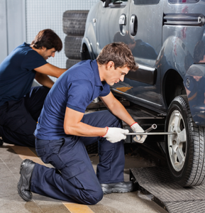 Two male mechanics fixing car tires