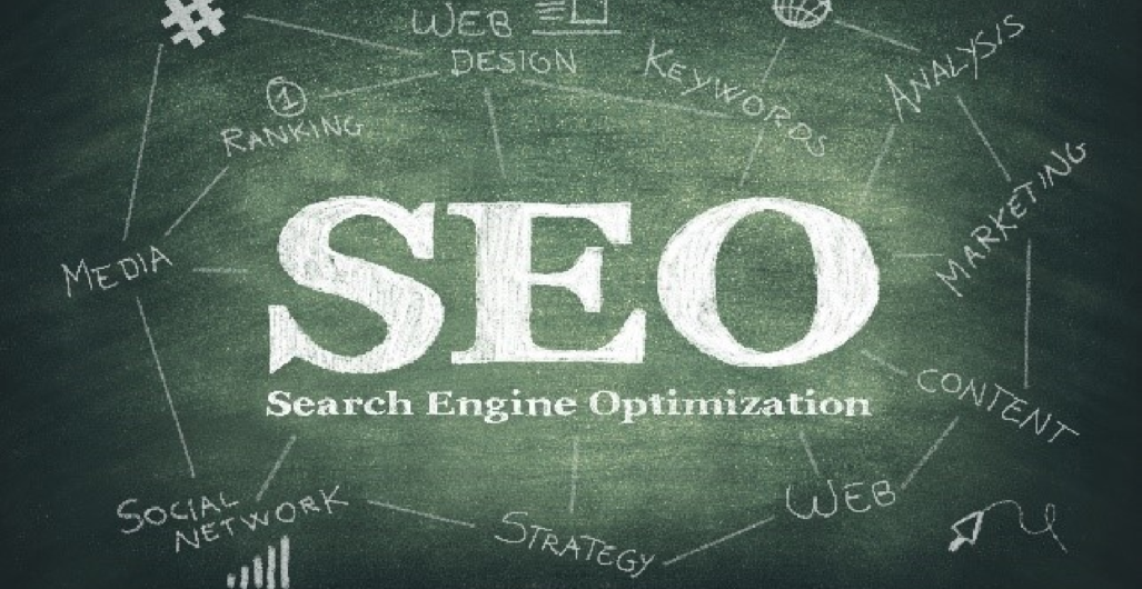 An image of a blackboard with the words “SEO”, “Search Engine Optimization” in the middle, and “Media”, “Social Network” “Strategy”, “Web”, “Content”, “Marketing”, “Analysis”, “Keywords”, “Web Design”, and “Ranking” written around it.