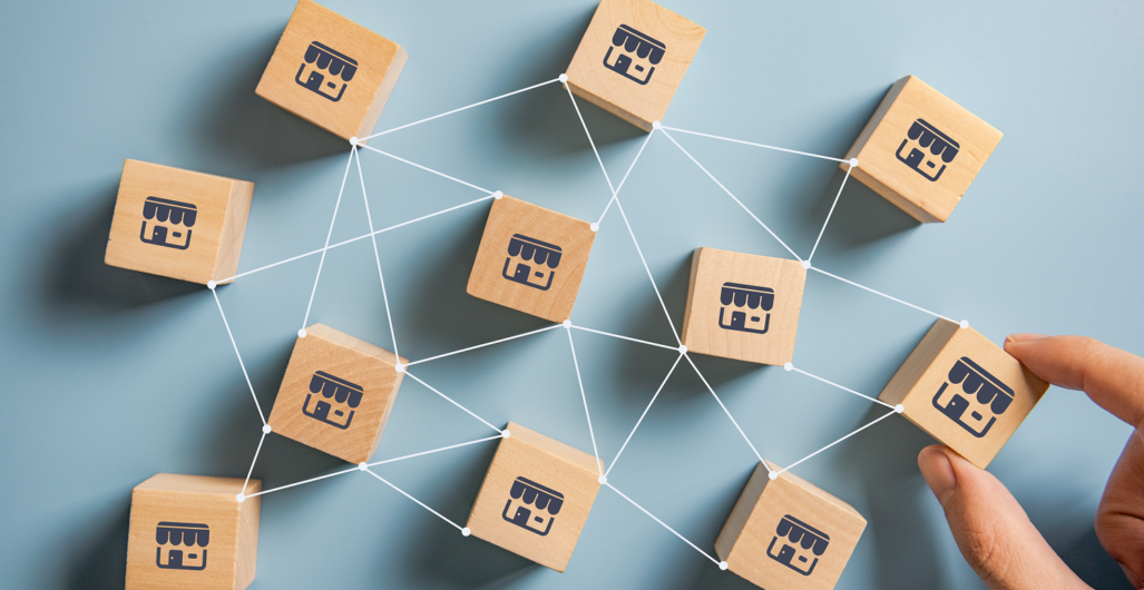 Small beige cubes with office building icons printed on them on top connected with lines on a blue background.
