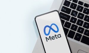 Meta logo on a phone with macbook keyboard in background 