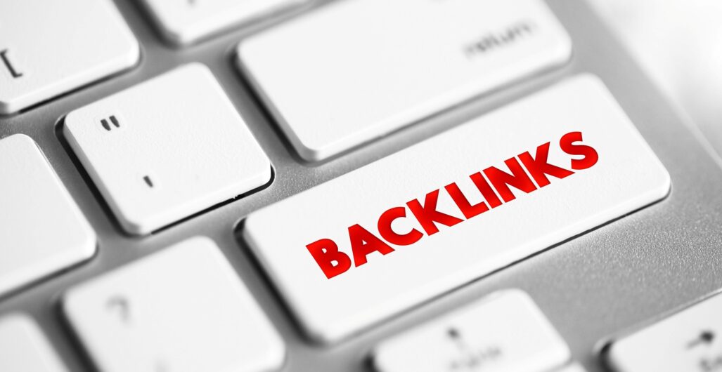 Close up of a computer keyboard with white keys and ”BACKLINKS” in red on one of the keys.