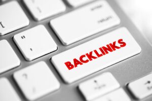 Close up of a computer keyboard with white keys and ”BACKLINKS” in red on one of the keys. 