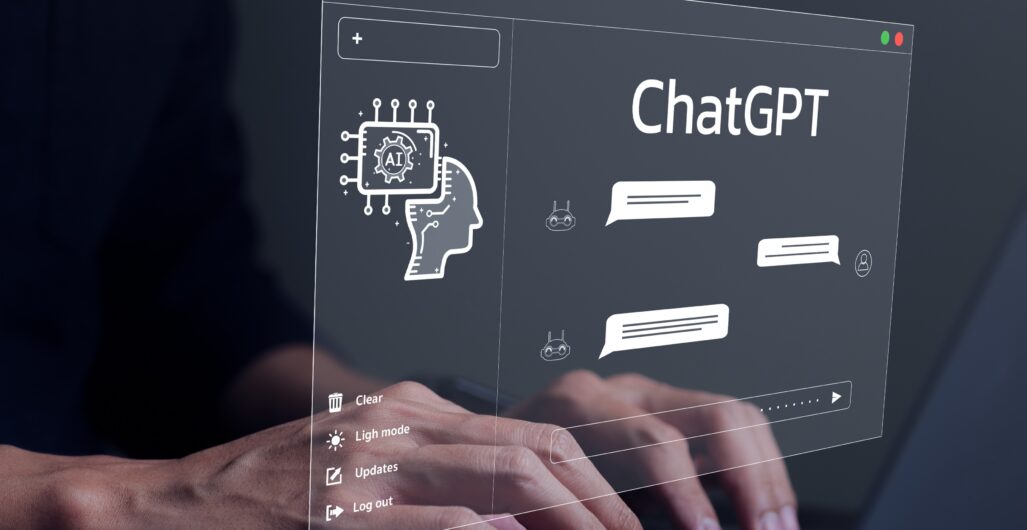 Conceptual image of a person’s hands over a laptop keyboard with a graphic depicting a ChatGPT window with chat bubbles in it hovering over the hands.