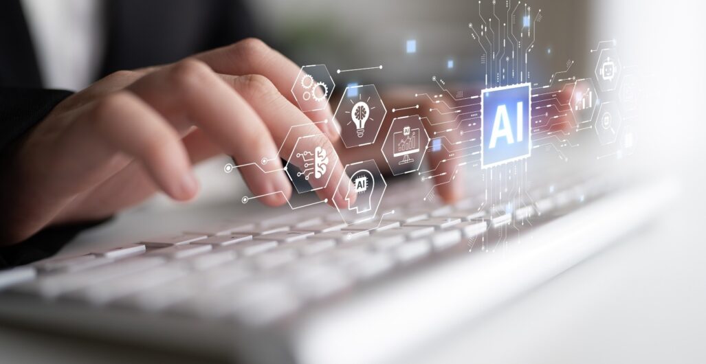 Fingers poised over a keyboard with icons floating above including one that represents AI.