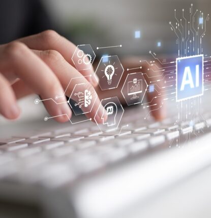 Fingers poised over a keyboard with icons floating above including one that represents AI.